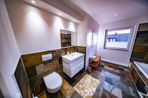 a bathroom with a white toilet and a sink at Ferienwohnung Auerose in Wesel +11 photos