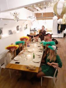 a group of people sitting around a table with hats on at Boat Hotel SIX Rotterdam in Rotterdam