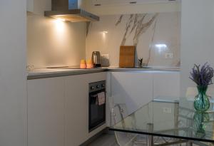 a kitchen with white cabinets and a glass counter top at Zambianchi Studio - Sostify in Bergamo