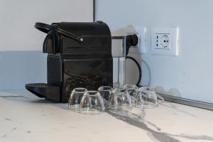 a black coffee maker sitting on a counter with wine glasses at Zambianchi Studio - Sostify in Bergamo +11 photos