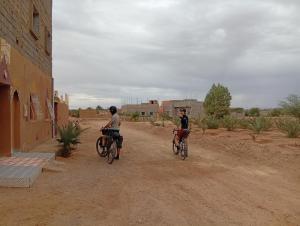 two people riding bikes down a dirt road at Dar Bani in Zagora