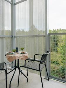 a table and chairs in a room with a large window at Sume by Larsen in Tallinn