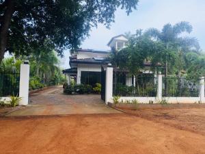 ティッサマハーラーマにあるHotel Winrose Tissamaharamaの塀と未舗装の家