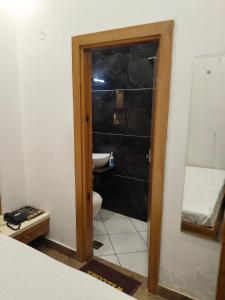 a bathroom with a toilet and a glass door at Comfort Inn in Sahāranpur +7 photos