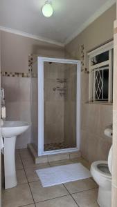 Un baño con ducha, inodoro y lavabo. en Harbour View Selfcatering, en Mossel Bay