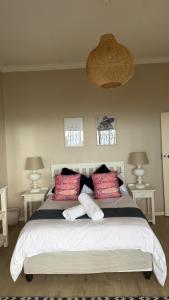 Un dormitorio con una gran cama blanca con dos lámparas. en Harbour View Selfcatering, en Mossel Bay