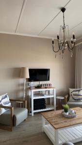 una sala de estar con un sofá y una mesa en Harbour View Selfcatering, en Mossel Bay 3 fotos más