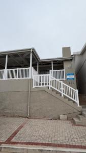 un edificio con una escalera blanca delante de un edificio en Harbour View Selfcatering, en Mossel Bay
