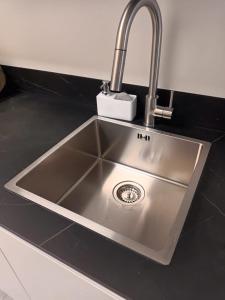 een roestvrijstalen aanrecht met een kraan bij Apartamento Playa de Gijon in Gijón