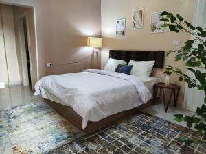 a bedroom with a bed with white sheets and a rug at Moon Homes in Downtown Cairo in Cairo