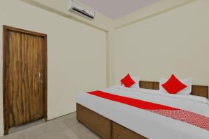 ein Schlafzimmer mit einem großen Bett mit roten Kissen in der Unterkunft HOTEL O SILVER DREAMS in Chinhat + 22 Fotos