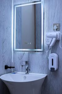 a bathroom with a white sink and a mirror at Serene 1bed, 1bath studio Apartment in Mbarara +4 photos