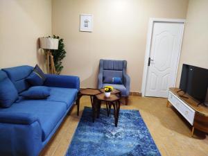 un salon avec un canapé bleu et une table dans l'établissement Moon Homes in Downtown Cairo, au Caire