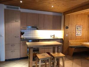 ハスリベルクにあるHaus Polluxの木製のキャビネットとテーブルと椅子を備えたキッチン