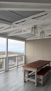 comedor con mesa y balcón en Harbour View Selfcatering, en Mossel Bay
