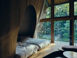 a bed in a room with a surfboard on the wall at SANU 2nd Home 那須2nd in Nasu