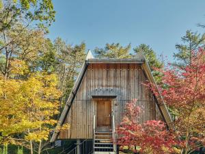 a wooden cabin with a door in the woods at SANU 2nd Home 那須2nd in Nasu