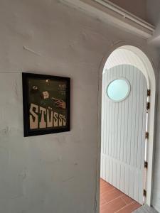 einen Flur mit einer weißen Tür und einem Bild an der Wand in der Unterkunft Dehut Boutique Homestay hut2 in Khon Kaen