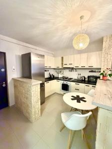 eine Küche mit weißen Schränken und einem Tisch und Stühlen in der Unterkunft FLH - Obralix Home in Sibiu