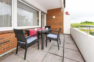 um pátio com uma mesa e cadeiras em uma varanda em Ferienwohnungen Alter Sielweg Wohnung 10 em Bensersiel mais 15 fotografias