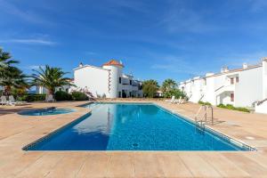 a swimming pool in front of a villa at Apto Familiar frente a cala in Cala en Forcat