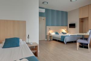 a hotel room with two beds and a desk at Hotel Zatoka in Gdańsk +44 photos