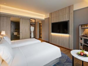 a hotel room with a bed and a television at Mövenpick Hotel Jakarta City Centre in Jakarta