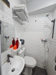 a white bathroom with a toilet and a sink at K & B Hostel in Hong Kong