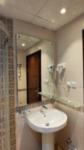 een badkamer met een wastafel en een grote spiegel bij ارجان المتميزة للشقق المخدومة in Jeddah