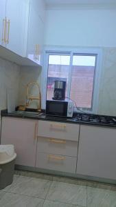 a kitchen with a stove and a microwave on a counter at Lelys Lof't 2 in Yaoundé +19 photos
