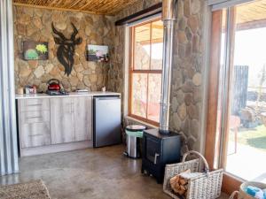 a kitchen with a refrigerator and a stone wall at Elandskop in Breede River DC +49 photos