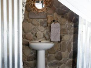 a bathroom with a sink and a stone wall at Elandskop in Breede River DC