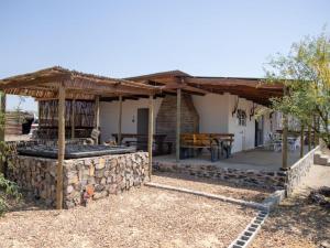 a patio with a stone wall and a wooden roof at Elandskop in Breede River DC