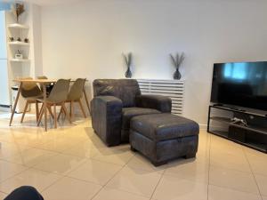 a living room with a chair and a television at Harbour Way in Shoreham-by-Sea