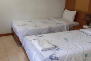 two beds in a hotel room with towels on them at Praew Mansion in Kamala Beach +18 photos