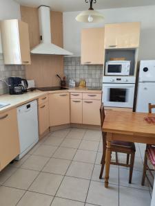 a kitchen with white appliances and a wooden table at Casa Helena in Saint-Florent