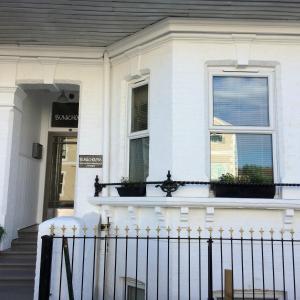 a white house with a balcony with plants on it at Bunkhouse Bournemouth in Bournemouth