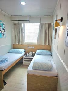 a room with two beds and a window at K & B Hostel in Hong Kong