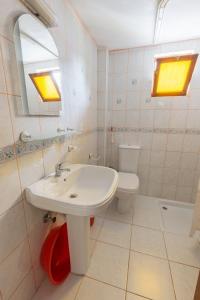 a white bathroom with a sink and a toilet at Flower Villa Apart in Kemer