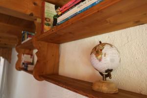 a wooden shelf with a globe and books on it at Casa Holamundo in Curtina