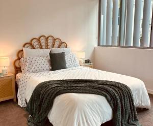 a bedroom with a large bed with a blanket on it at The Broadbeach Retreat in Gold Coast