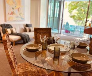 a dining room table with plates and glasses on it at The Broadbeach Retreat in Gold Coast