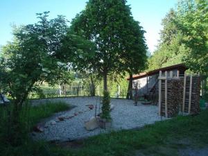 a garden with a fence and a tree and a building at Steinern in Ufhusen