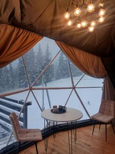 a room with a table and chairs in a tent at Глемпінг Перлина Карпат in Dragobrat