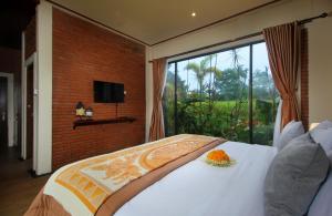 a bedroom with a bed and a large window at 2 Bedrooms Private Pool Villa Tegalalang-Ubud in Tegalalang