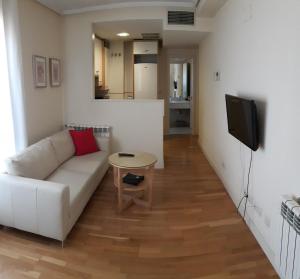 a living room with a white couch and a table at Cituspace Las Tablas Azofra in Madrid