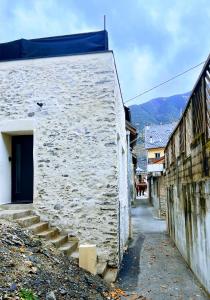 ein weißes Gebäude mit blauer Tür auf einer Straße in der Unterkunft Le Vieux Bourg Apartment 4, Spacious 3 bedroom Apartment, Ski & Cycle in Le Bourg-dʼOisans