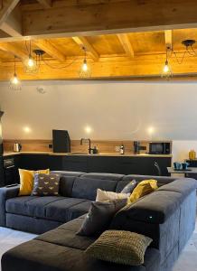 ein Wohnzimmer mit 2 blauen Sofas und einer Küche in der Unterkunft Le Vieux Bourg Apartment 4, Spacious 3 bedroom Apartment, Ski & Cycle in Le Bourg-dʼOisans