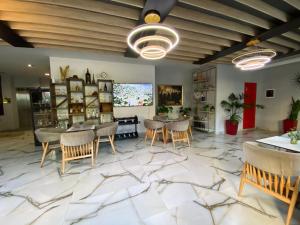 a living room with tables and chairs on a marble floor at Peaky Hotel in Durrës