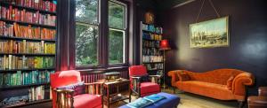 eine Bibliothek mit Sofa, Stühlen und Büchern in der Unterkunft Stow House in Aysgarth